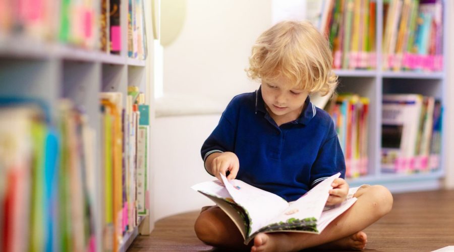 Young child reading a book - books about the ocean for kids