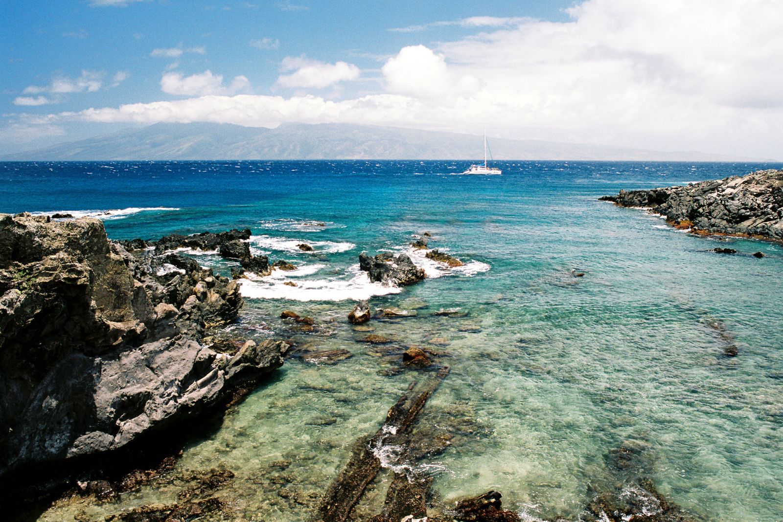 why manta ray tourism is still unregulated Image of boat navigating near the Hawaii shores to illustrate our article about the lack of regulations for manta ray tourism